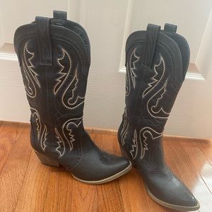 Black cowboy boots with tan and blue/gray stitching. Gold accent around heel.